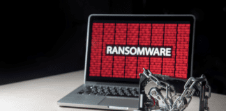 Laptop infected by ransomware and a locked harddrive near money with a key on top.